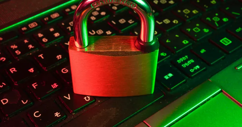 A padlock resting on a backlit laptop keyboard
