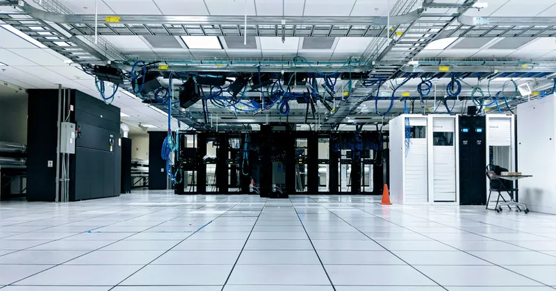 A bright data center with server racks and overhead cabling